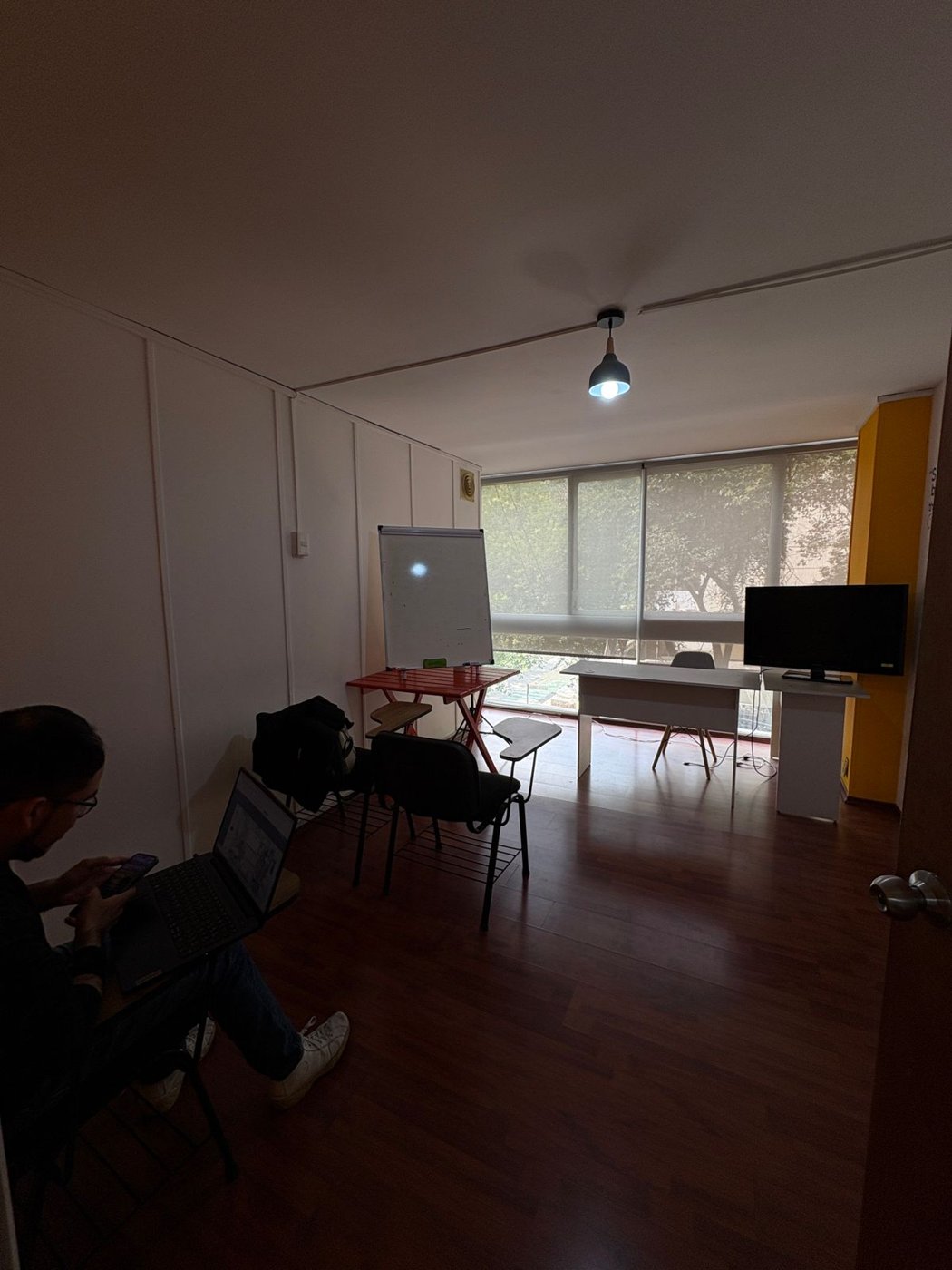 Sala de clases con pizarrón y pantalla